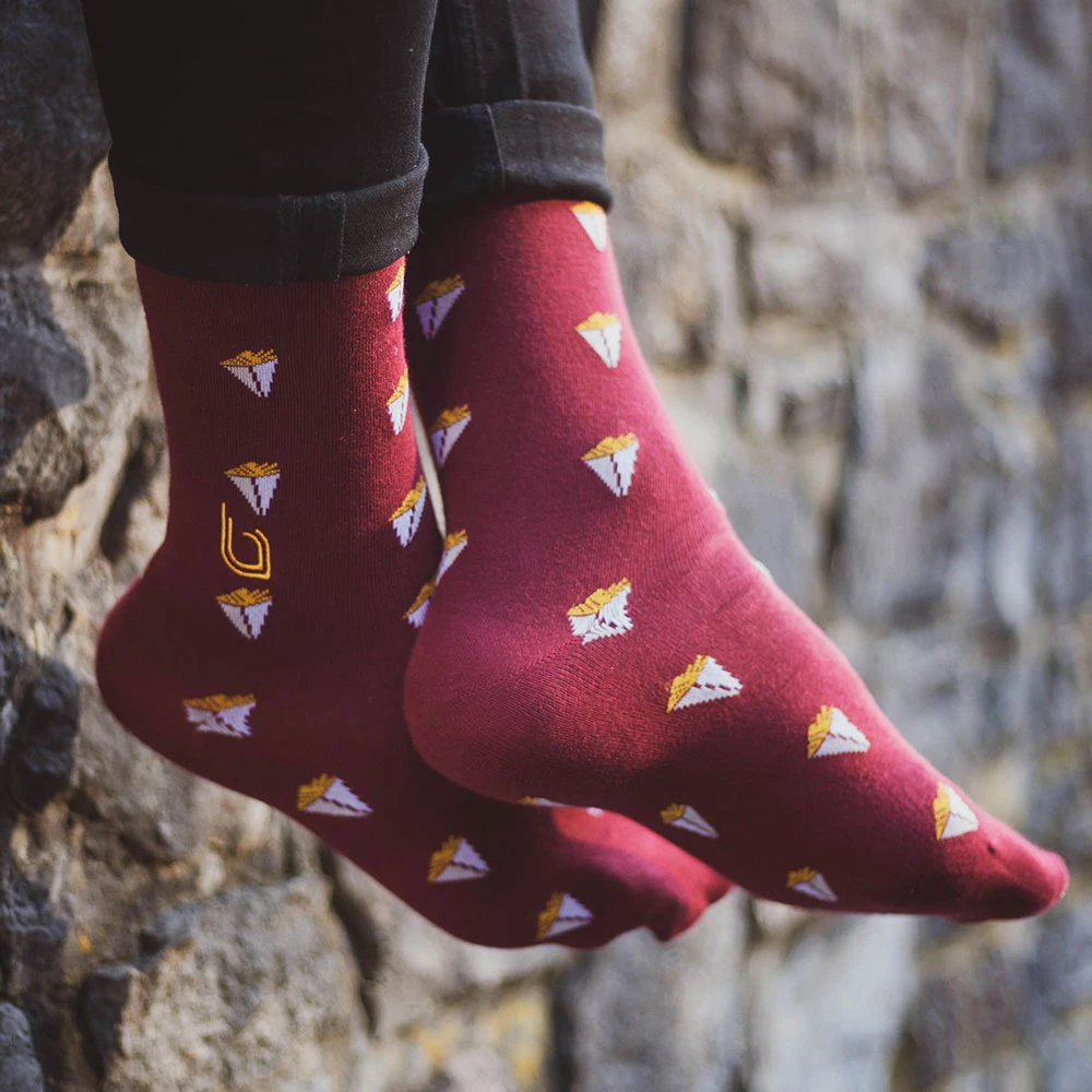 Chaussettes hautes bordeaux avec logo jaune et motifs frites - Style original et coloré Chaussettes hautes bordeaux avec logo jaune et motifs de paquets de frites - Chaussettes fun et originales